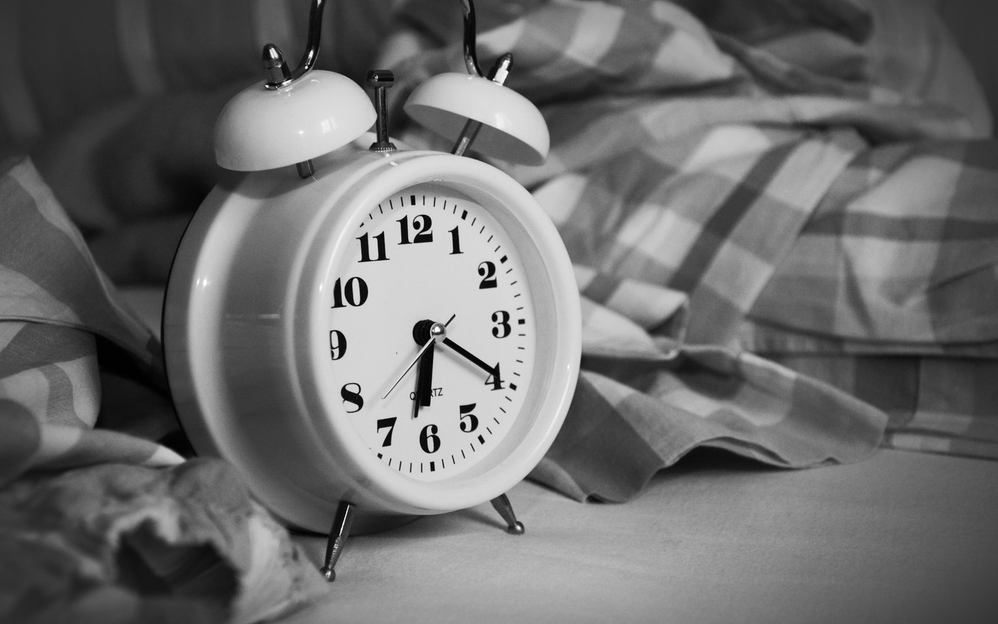 Alarm clok beside a bed