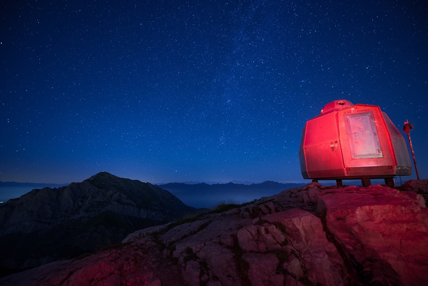 A red house over the rocks at night blue sky