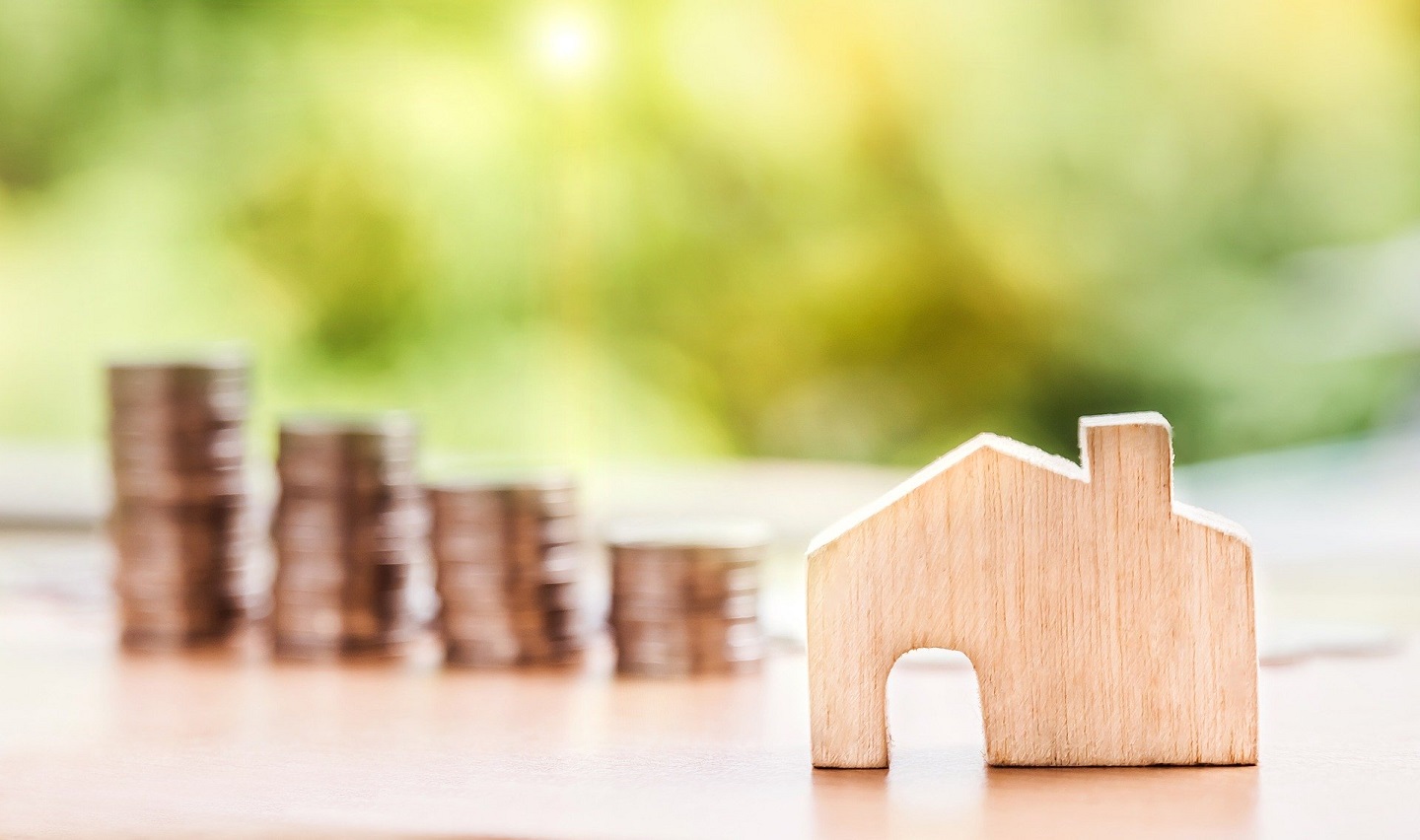 stack of coins and miniature home
