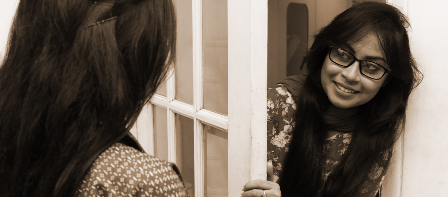 woman talking to another woman from behind a door