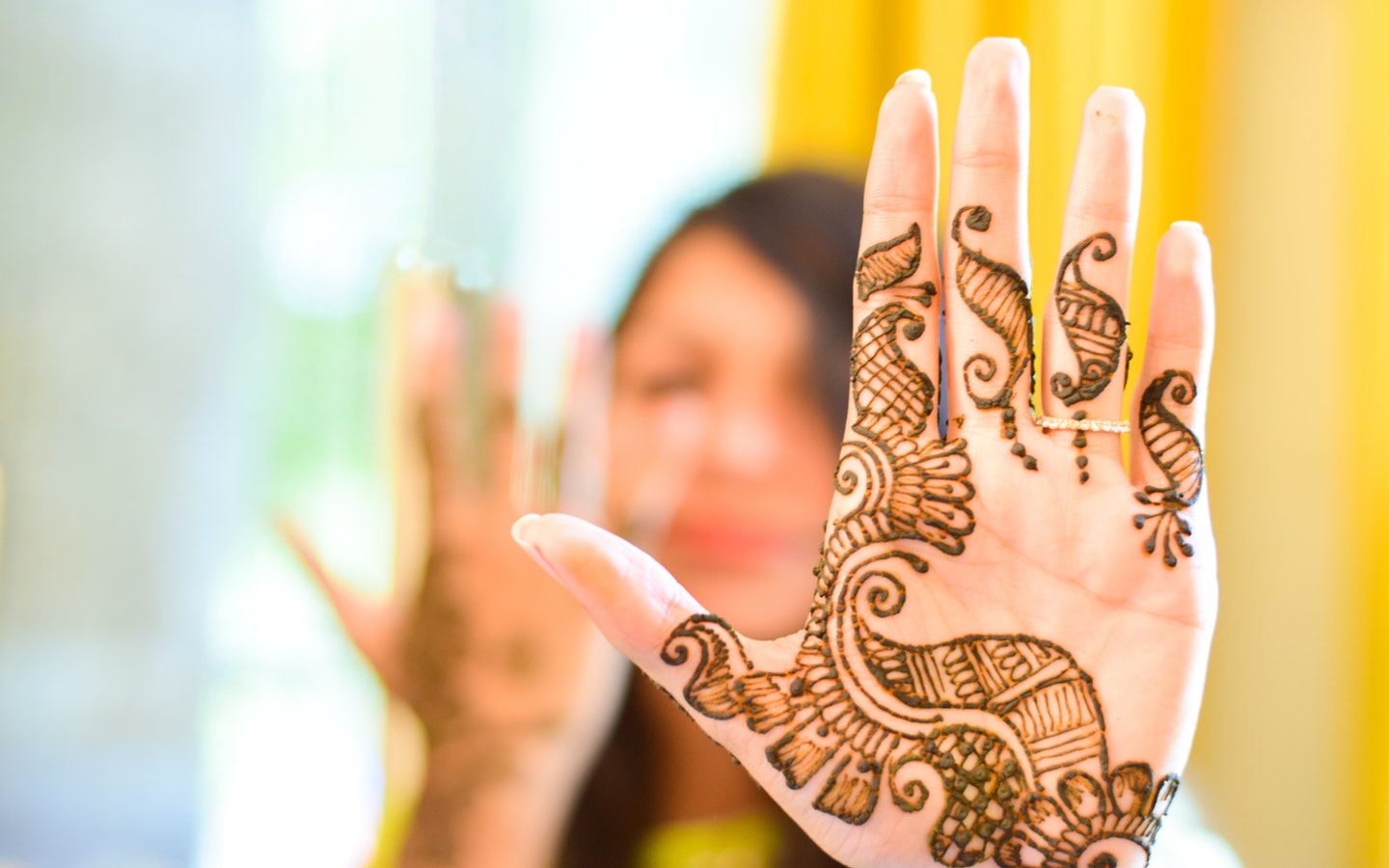a girl is showing henna on her hand